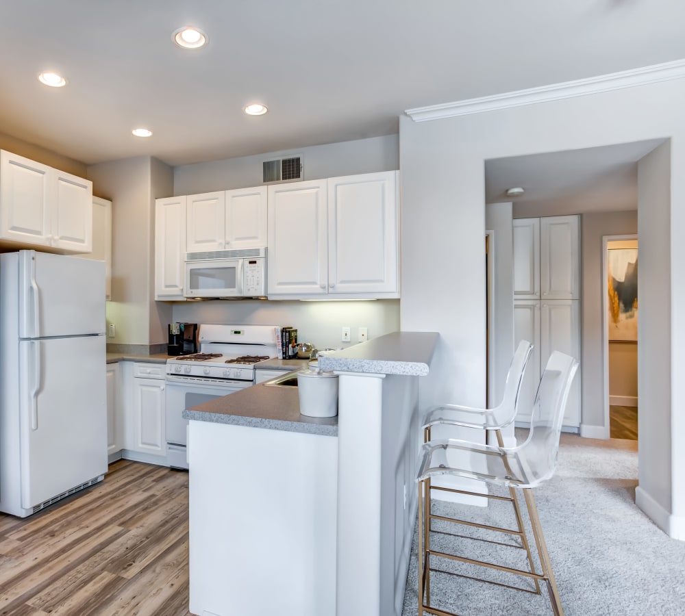 Modern kitchen with bright white appliances and cabinetry in a model home at Sofi Highlands in San Diego, California