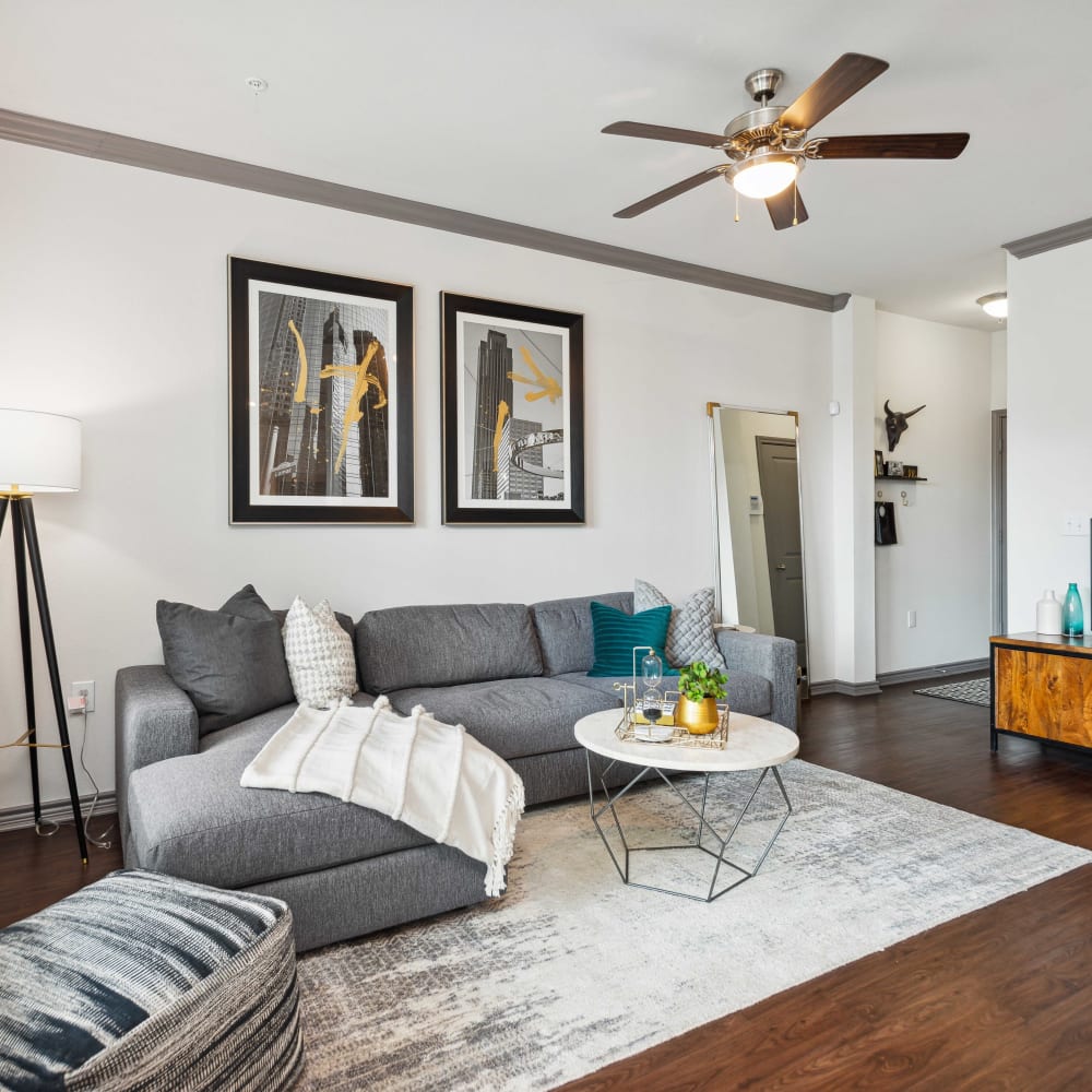 Living room of a model apartment with wood-style plank flooring at Haven at Eldridge in Houston, Texas