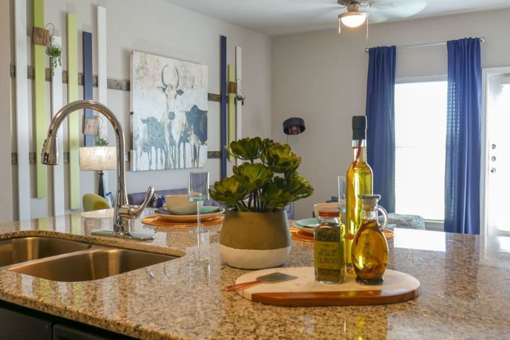 Kitchen island with a view of the living room at Biltmore at the Park in Pflugerville, Texas