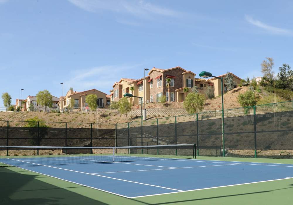 Enjoy panoramic views from this vibrant tennis court surrounded by charming hillside homes with lush landscaping at Cresta Bella in San Diego, California