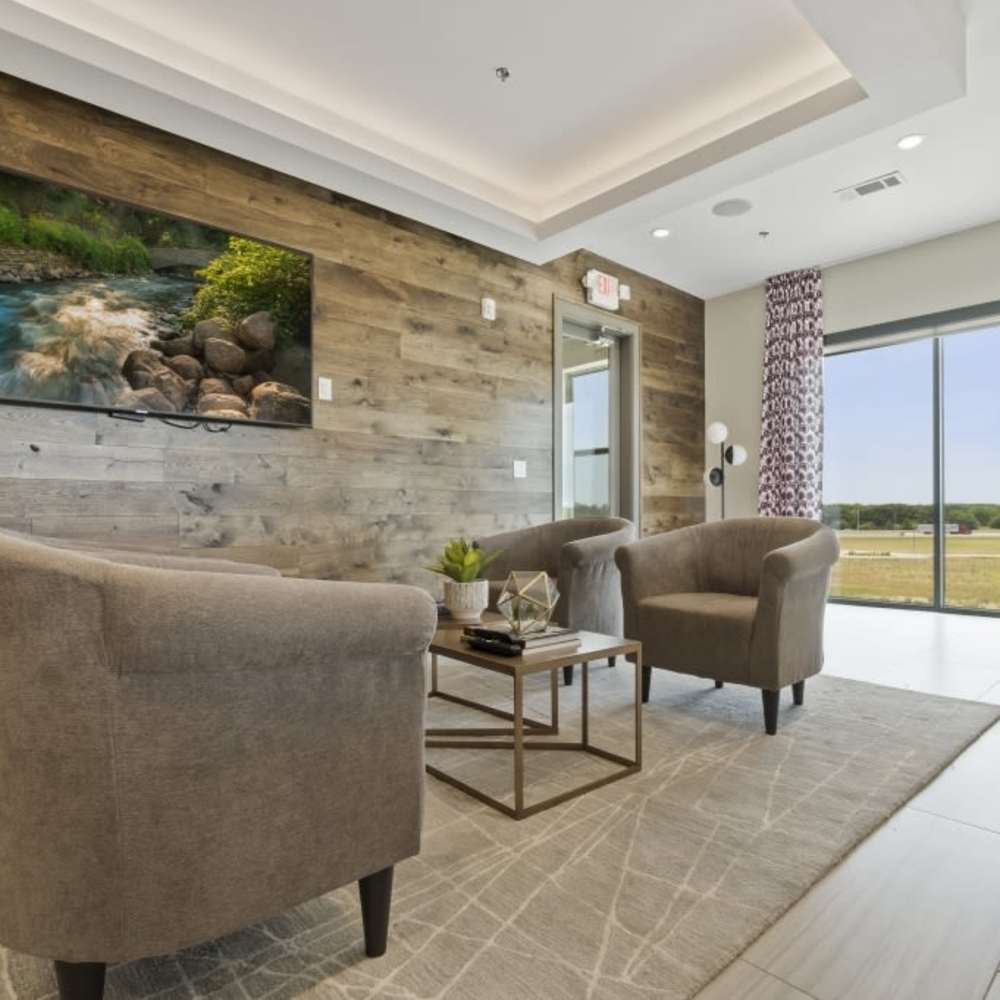 Common community area with chairs and large window at Millennium Place in Corinth, Texas