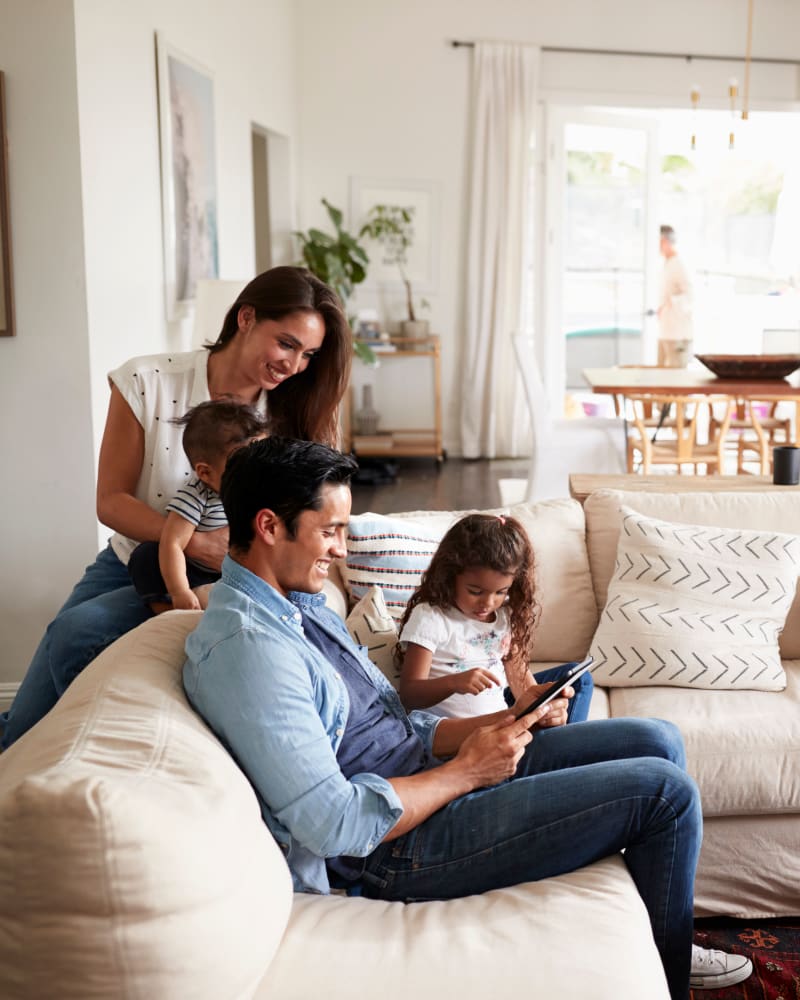 Family enjoying their living room at Park Fountains at Preston Hollow in Dallas, Texas