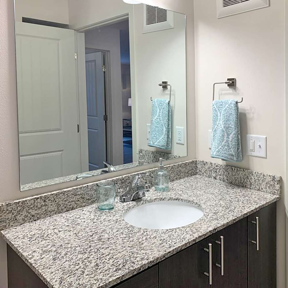 Bright bathroom with vanity light, mirror and sink at Depot on Main in Zimmerman, Minnesota