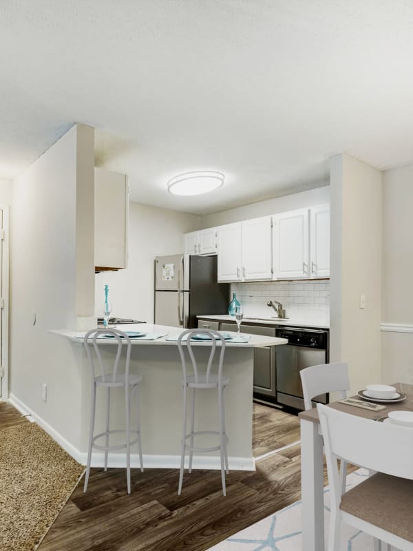Apartment kitchen with wood-style flooring at The Greens At Braelinn in Peachtree City, Georgia