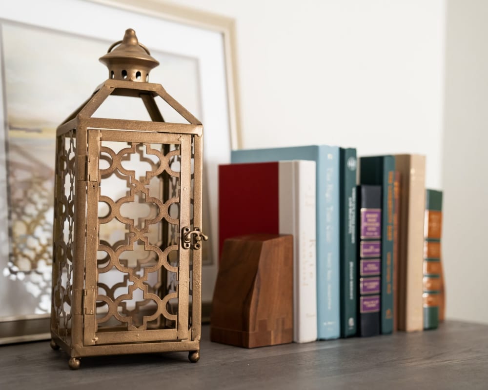 Decorative lantern and multiple books on a shelf at The Pillars of Lakeville in Lakeville, Minnesota