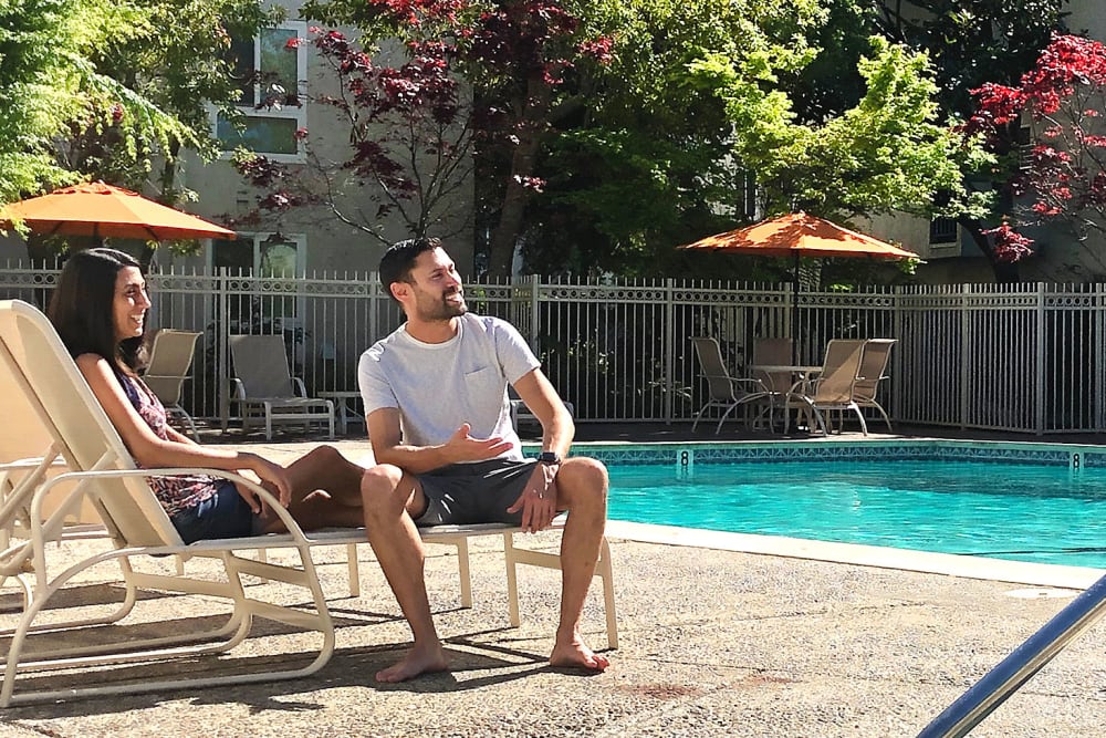 Couple relaxing the by pool at Newport Apartments in Campbell, California