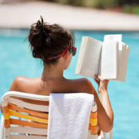 Resident reading a book on the pool at Copper Mill in Austin, Texas