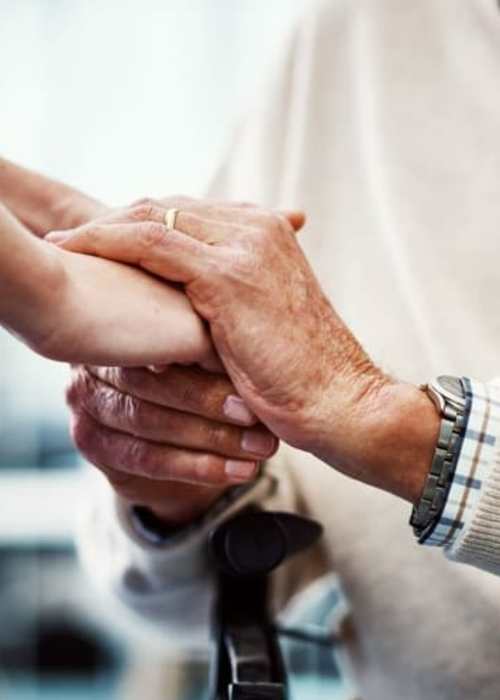 Staff member holding a resident's hands at Grand Villa of Port Charlotte in Port Charlotte, Florida