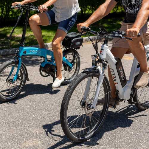 Two cyclists riding electric bikes on pavement at Botanica in Mandeville, Louisiana