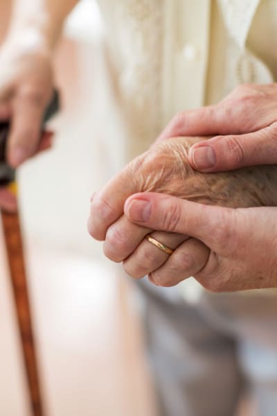 Caretaker holding the hand of a resident at a Living Care Lifestyles community