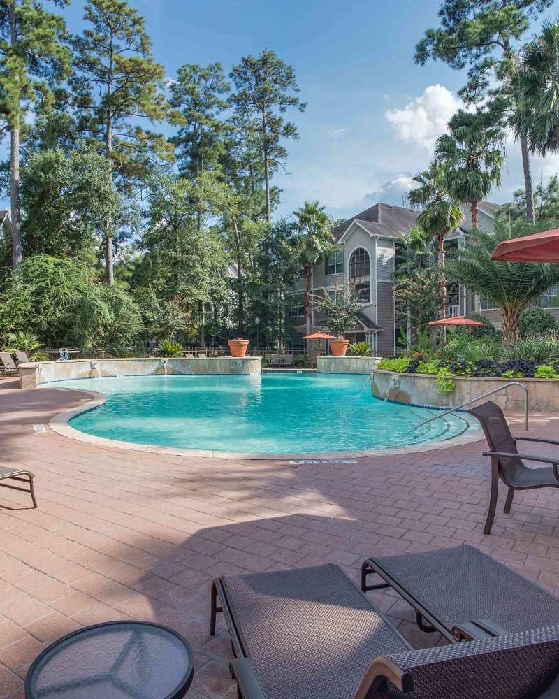 Swimming pool with lounge chairs at Whispering Pines Ranch in The Woodlands, Texas