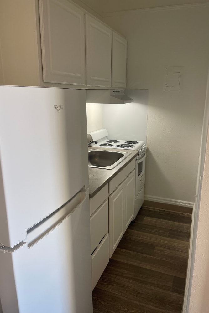 Kitchen with wood flooring and white appliances at The Winthrop in Tacoma, Washington