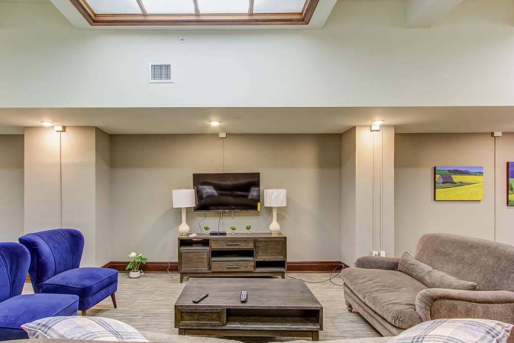 Spacious lounge area with blue chairs and wooden coffee table at 43 Town Square in Lima, Ohio