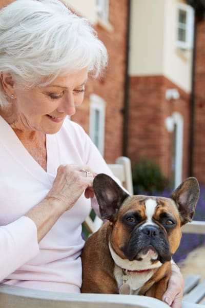 Female resident sitting with her dog at Quail Park at Shannon Ranch in Visalia, California
