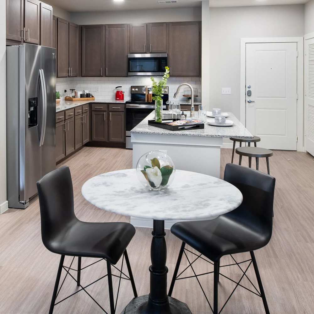 Open layout kitchen with dining area at August Friendswood in Friendswood, Texas