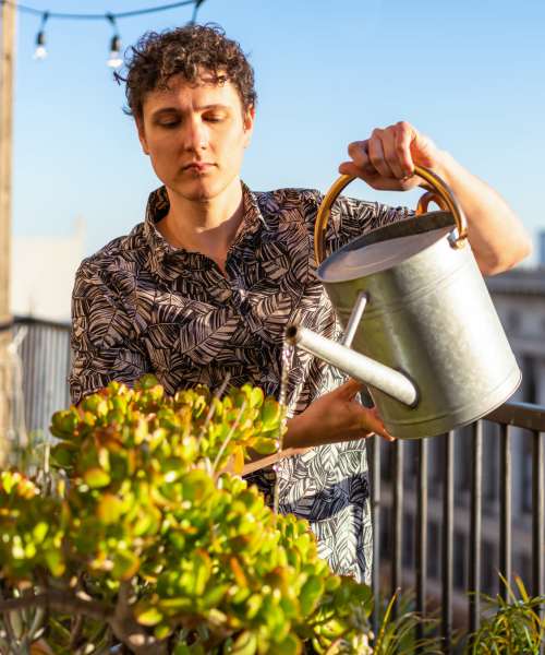 Resident watering plants at Sagewood Estates in Portland, Oregon
