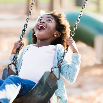 A child swinging on a swing at a playground near Discovery Village in Joint Base Lewis McChord, Washington