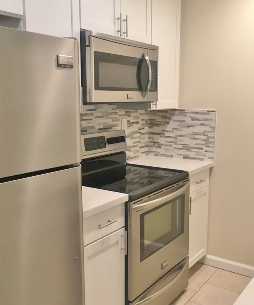 Kitchen with white cabinetry and stainless-steel appliances at Haven Warner Center in Canoga Park, California