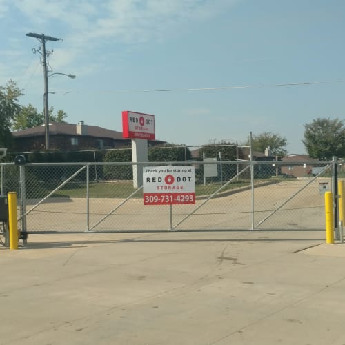 Electronic gate with a Red Dot Storage sign at the entrance to Red Dot Storage in Bloomington, Illinois