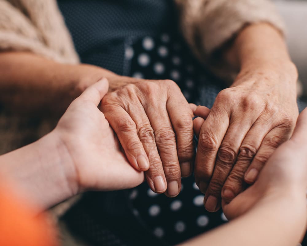 Resident holding hands with a younger person at Edencrest at Tuscany in Altoona, Iowa.