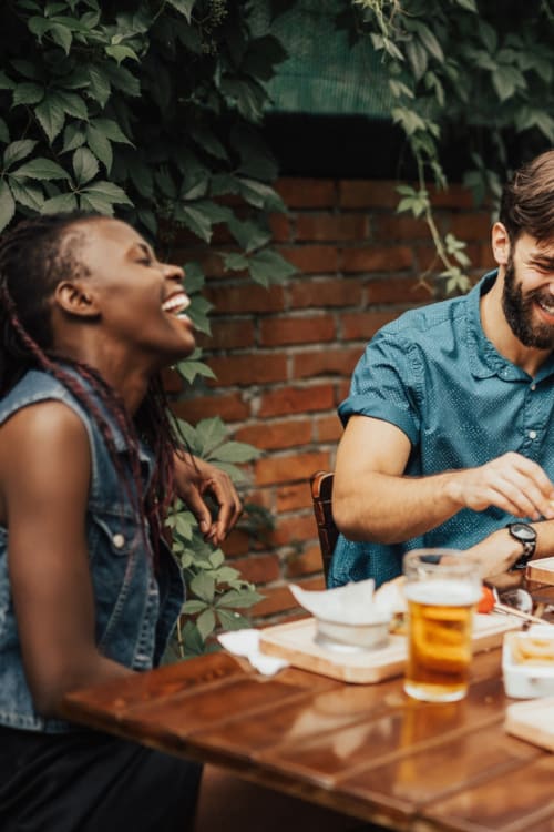 Woman laughing while hanging with her friends at a cool beer garden near Dorchester House in Washington, District of Columbia