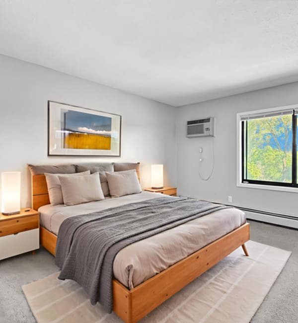 Bedroom with window and large size bed at Equinox Apartments in Saint Anthony, Minnesota