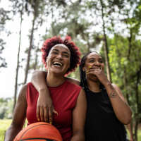 Women laughing with basketball outdoors near 81 West Apartments in Fort Myers, Florida