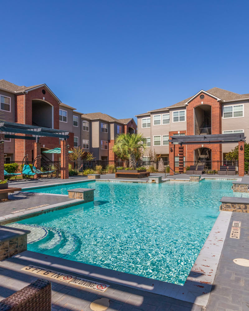 Pool and exterior of building at Augusta Meadows in Tomball, Texas