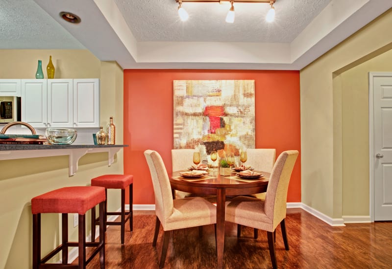 Dinning room adjacent to an open kitchen design with bar seating at Avia at North Springs in Atlanta, Georgia