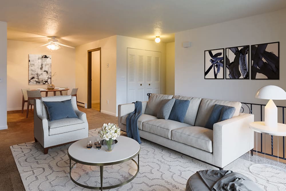 Model living room with wood-style flooring at Crossroads Apartments & Townhomes in Spencerport, New York