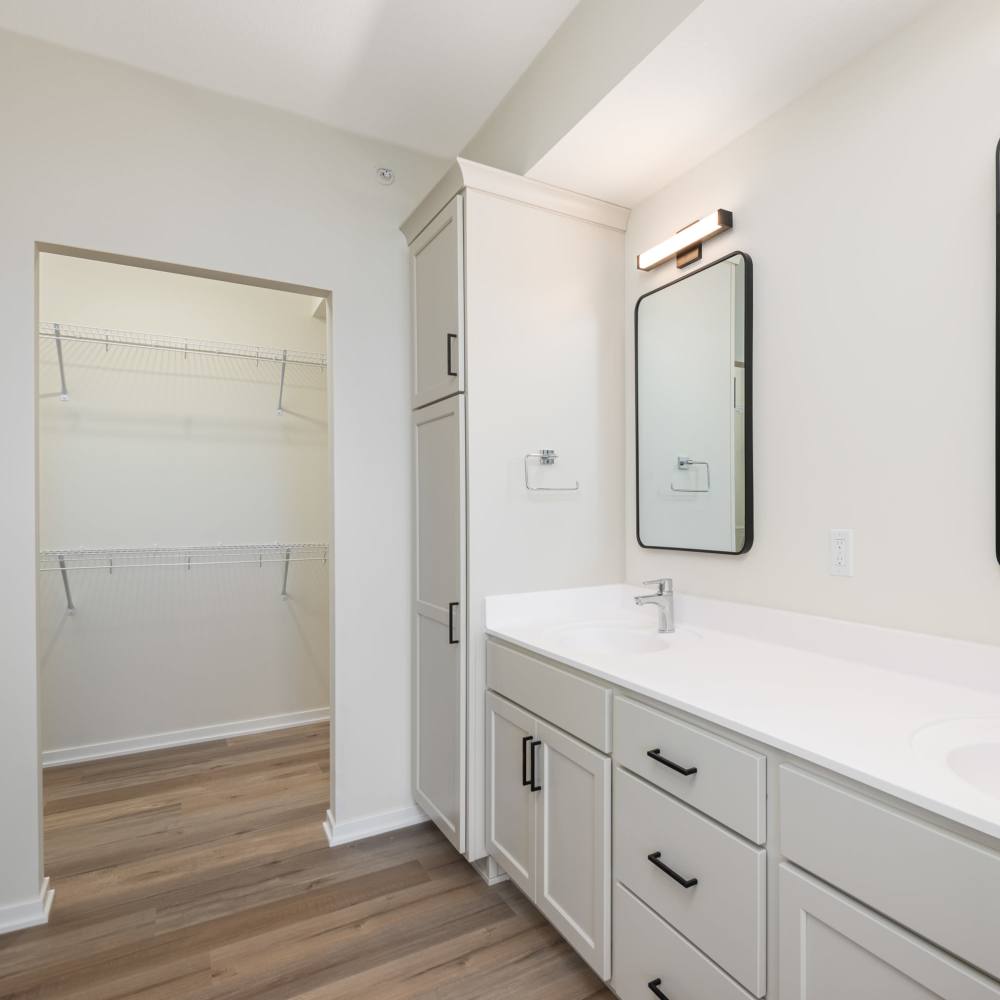 Bathroom with large double sink vanity and access to closet at The Uptown Apartments in Waconia, Minnesota