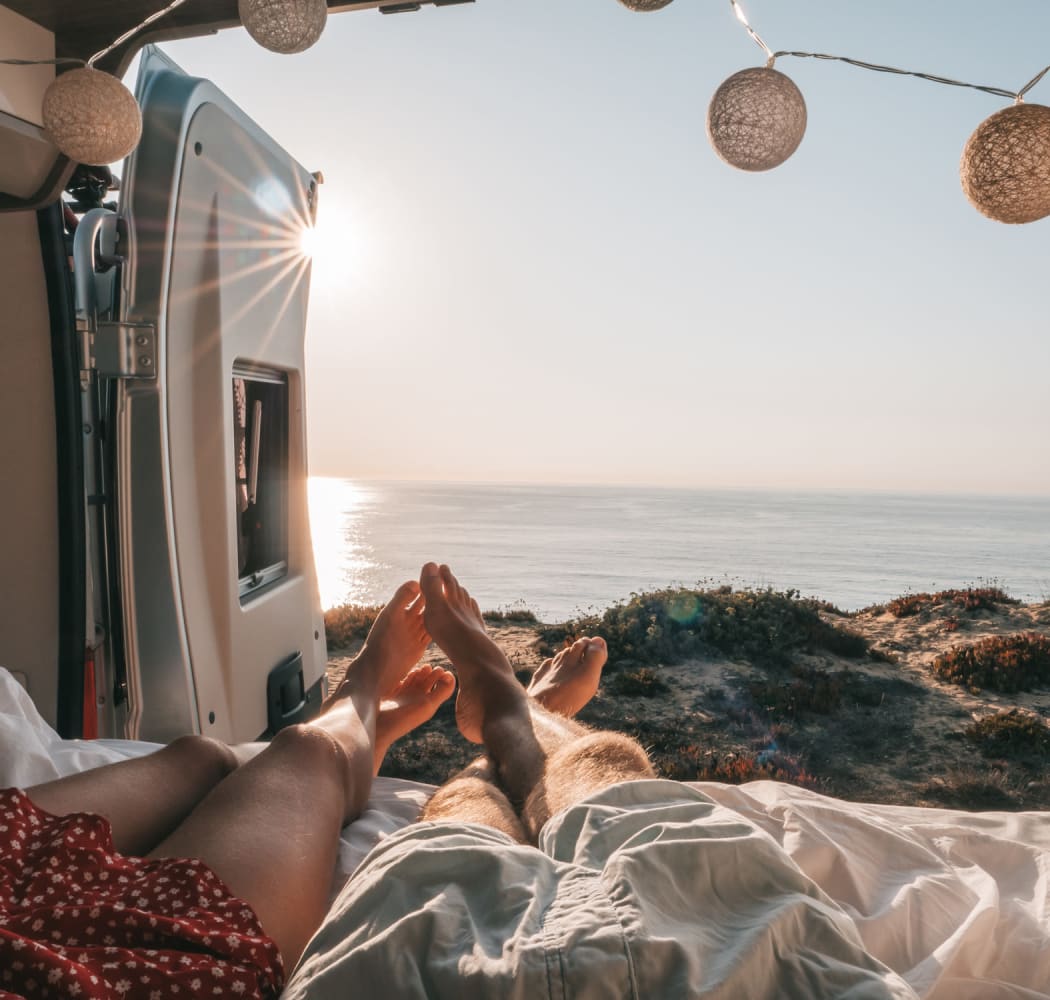 A couple laying in the back of their van with the doors open near BestBox Storage - Red Lodge in Red Lodge, Montana