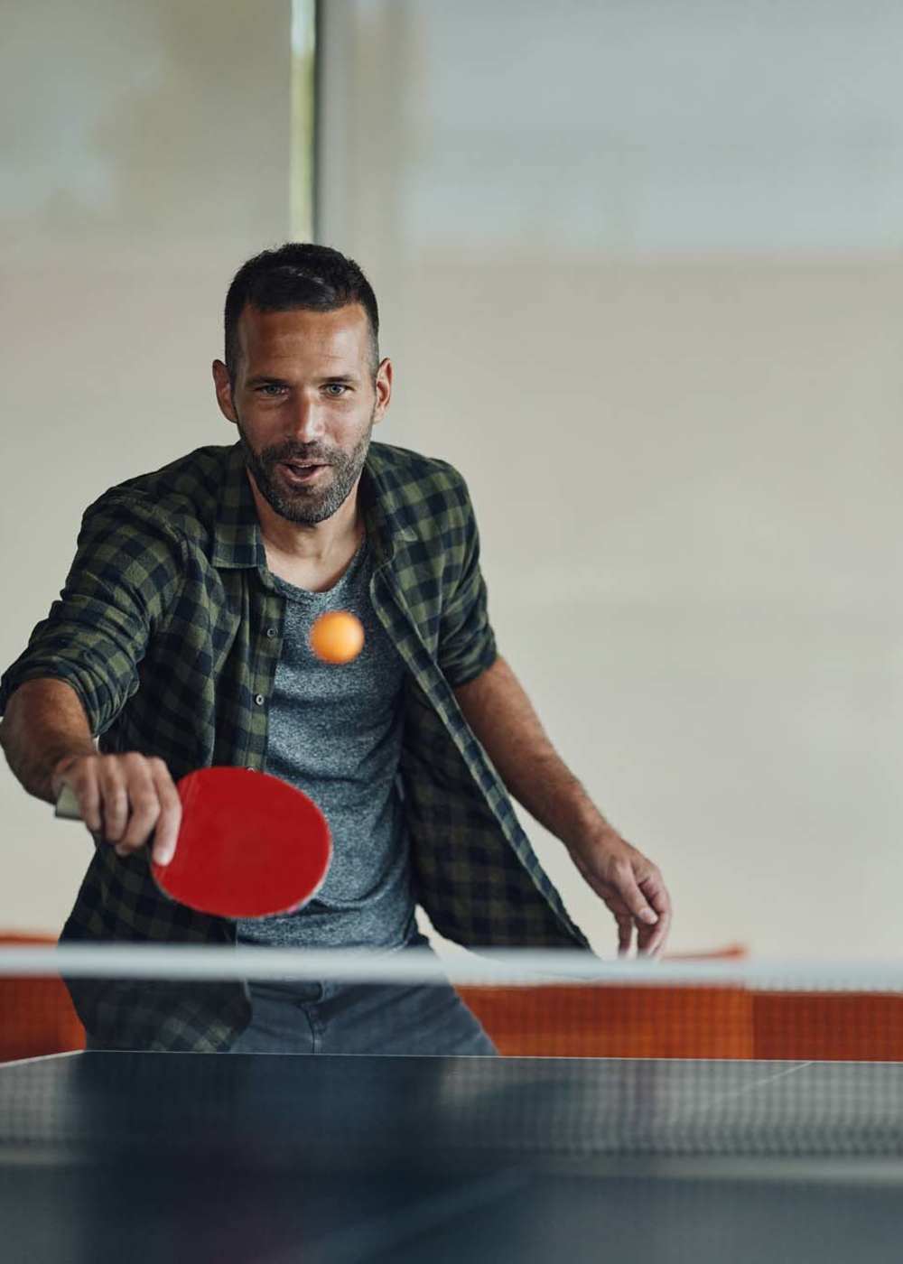 Residents playing ping pong game in clubhouse at The Hardison in Salt Lake City, Utah 