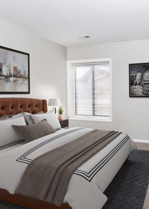 Model bedroom with plush carpeting and a ceiling fan at The Flats at Columbia Pike in Silver Spring, Maryland