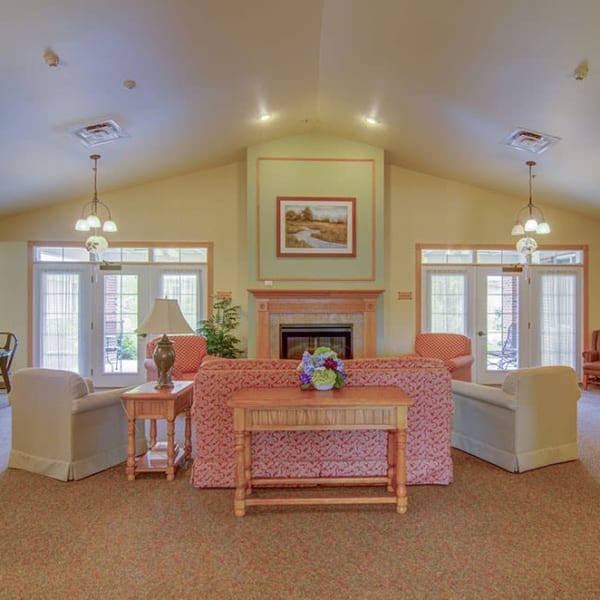 Common space for residents with large windows and cozy furnishings at Randall Residence of McHenry in McHenry, Illinois