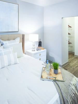 Elegant model master bedroom with hardwood style flooring and a ceiling fan at Anatole at the Pines in Conroe, Texas