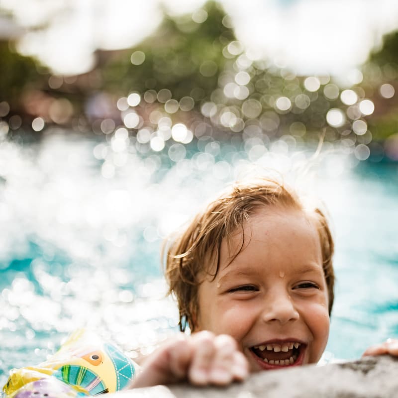 Resident enjoying the swimming pool at Oro Stone Oak in San Antonio, Texas