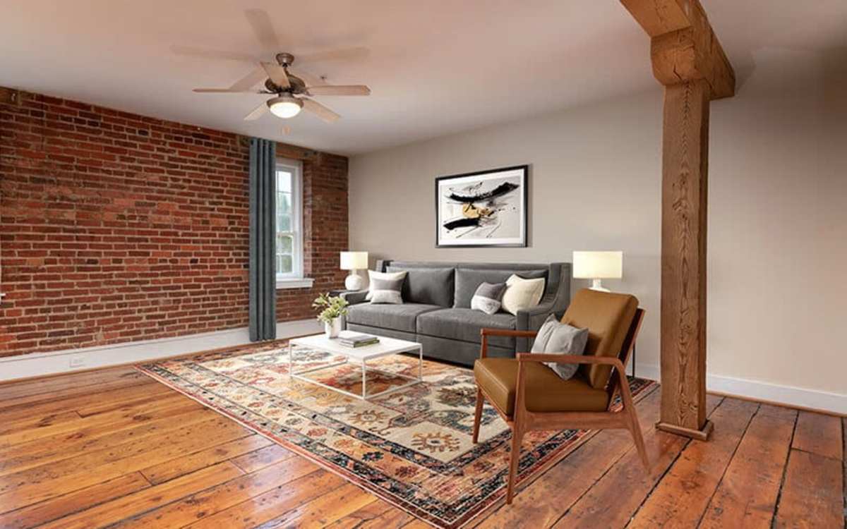 Spacious and well-furnished living area with hardwood flooring at High Street Lofts in Petersburg, Virginia
