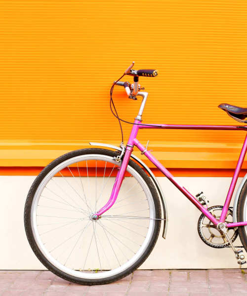 Bicycle leaning against an orange wall near Somerset Court in Baltimore, Maryland