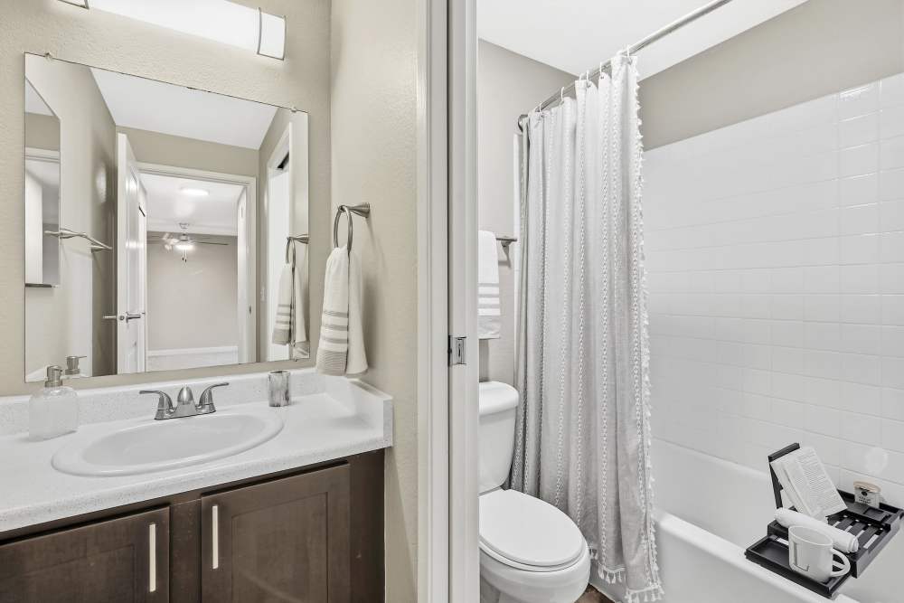 Brown renovated bathroom with a tub at Latitude Apartments in Everett, Washington