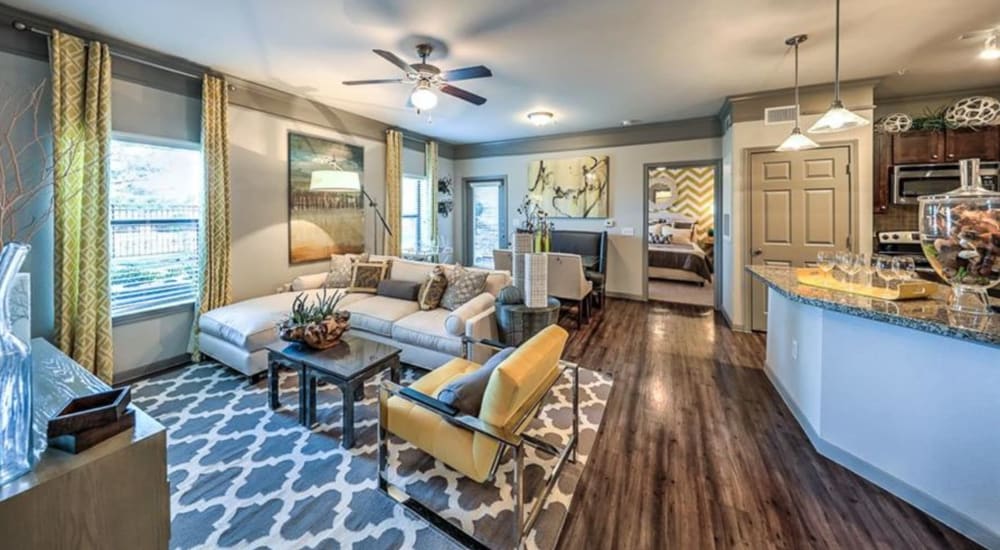 Leather couch and a comfortable chair in a model home's living space at Waterstone at Cinco Ranch in Katy, Texas