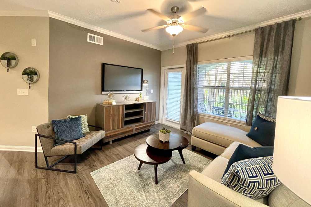 Spacious living room with comfortable couch, tea table, and TV setup at The Abbey at Barker Cypress in Houston, Texas