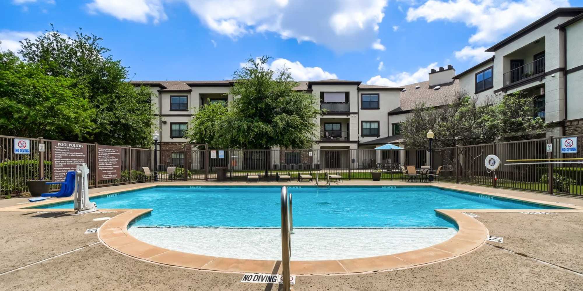 Modern apartment community withoutdoor swimming pool, balconies, and a welcoming entrance at Lindbergh Parc Senior Apartments in Fort Worth, Texas