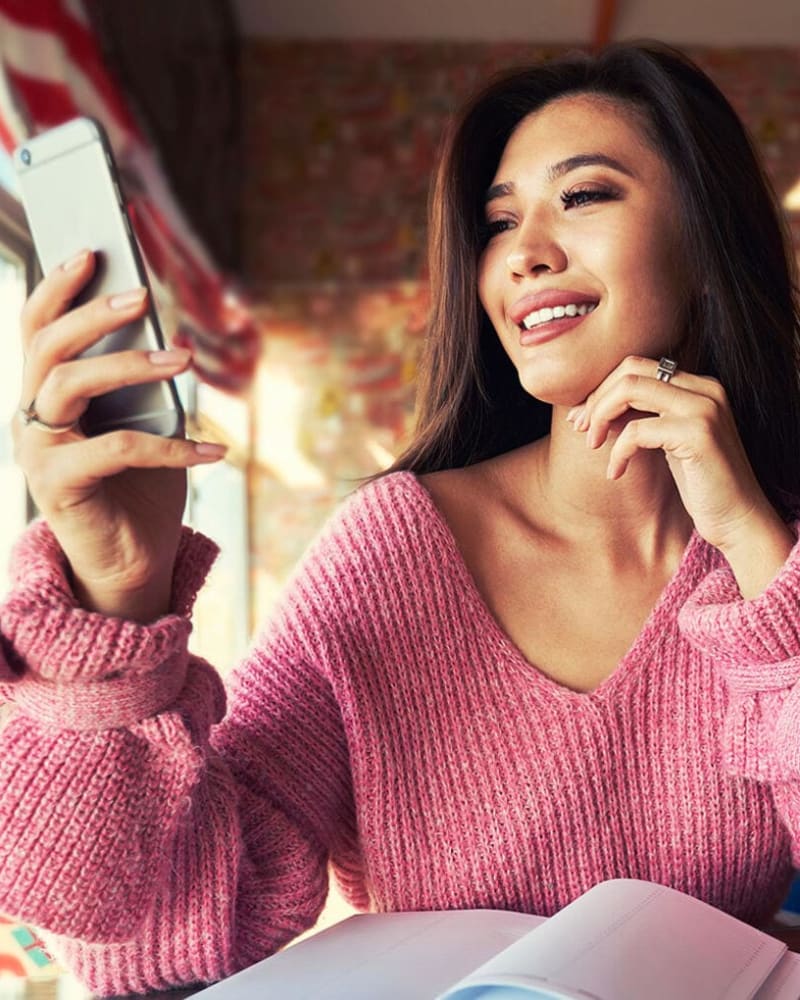 A resident looking at her phone at Lincoln Landing in Hayward, California