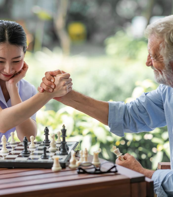 Staff member and resident playing chess at The Sanctuary at St. Cloud in St Cloud, Minnesota