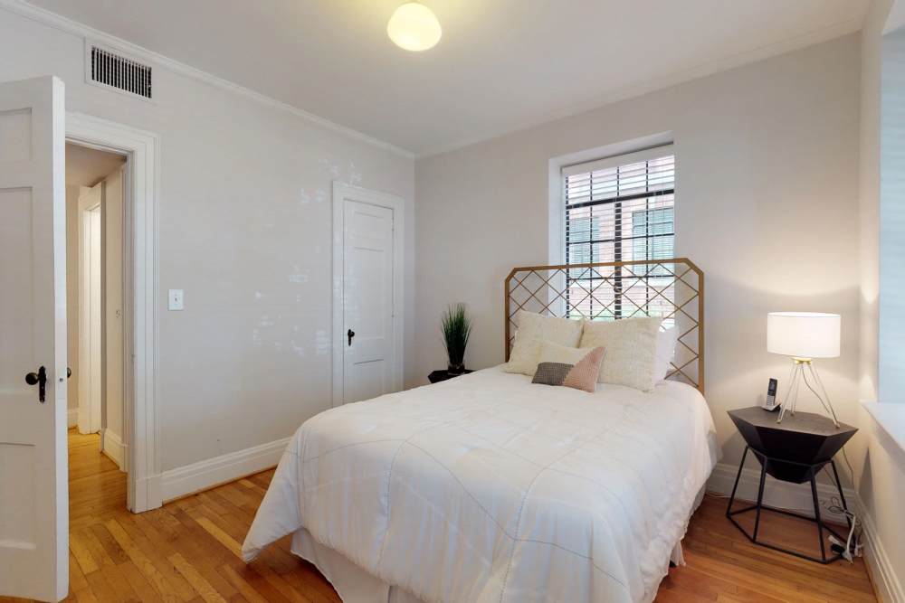 Bedroom with large comfortable bed at Historic Boylan Apartments in Raleigh, North Carolina