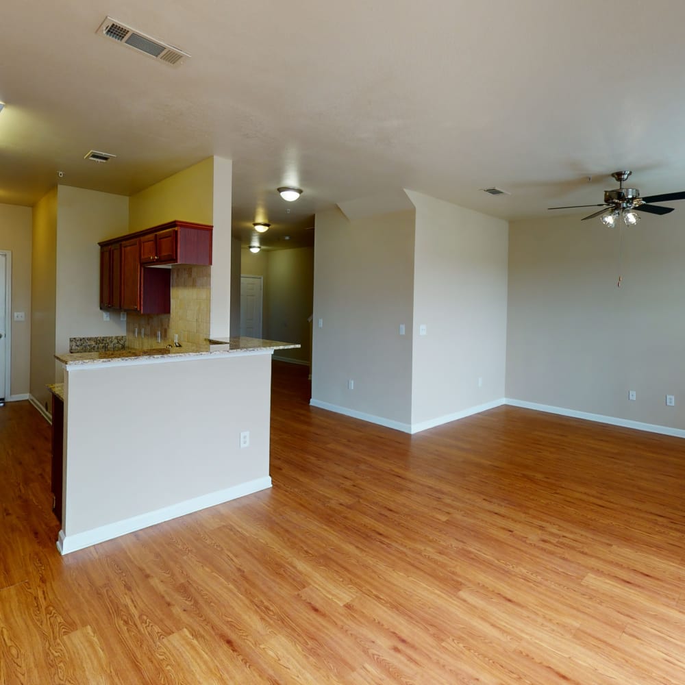 Hardwood flooring and ceiling fans in a townhome's lower-floor living areas at Oaks Estates of Coppell in Coppell, Texas