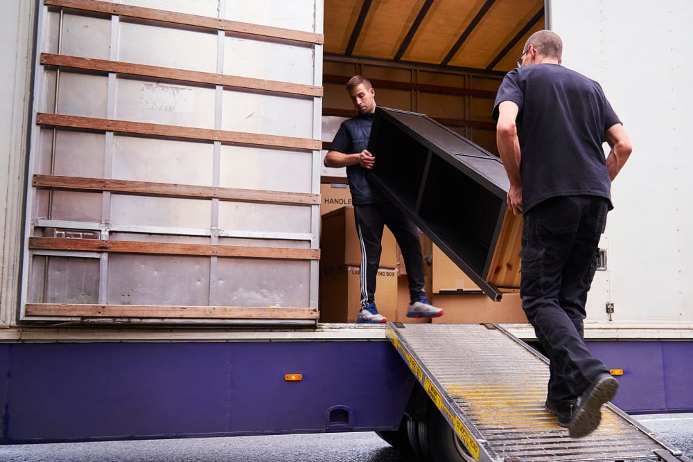 Two men loading furniture onto a moving truck at A-American Self Storage in Reno, Nevada