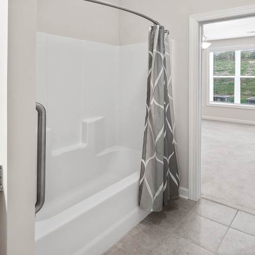 Bathtub and shower area in apartment bathroom at Brittany Place Hendersonville in Henderson, North Carolina