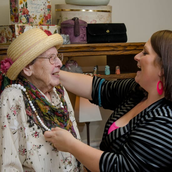 Staff helping a resident try on jewelry at Carefield Castro Valley in Castro Valley, California